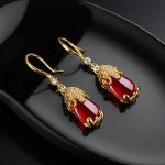 Стилни и елегантни ретро обеци Тея с червен камък и финни кристалчета във формата на драконови глави.