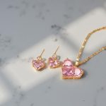 Комплектът от неръждаема стомана "Роуз" се състои от финно колие с медальон и обеци във формата на сърце с голям розов кристал.