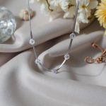 Нежно колие с 5 цветя от бял седеф, поставени на сребриста верижка изработена от висококачествена стомана.