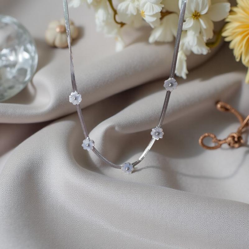 Нежно колие с 5 цветя от бял седеф, поставени на сребриста верижка изработена от висококачествена стомана.