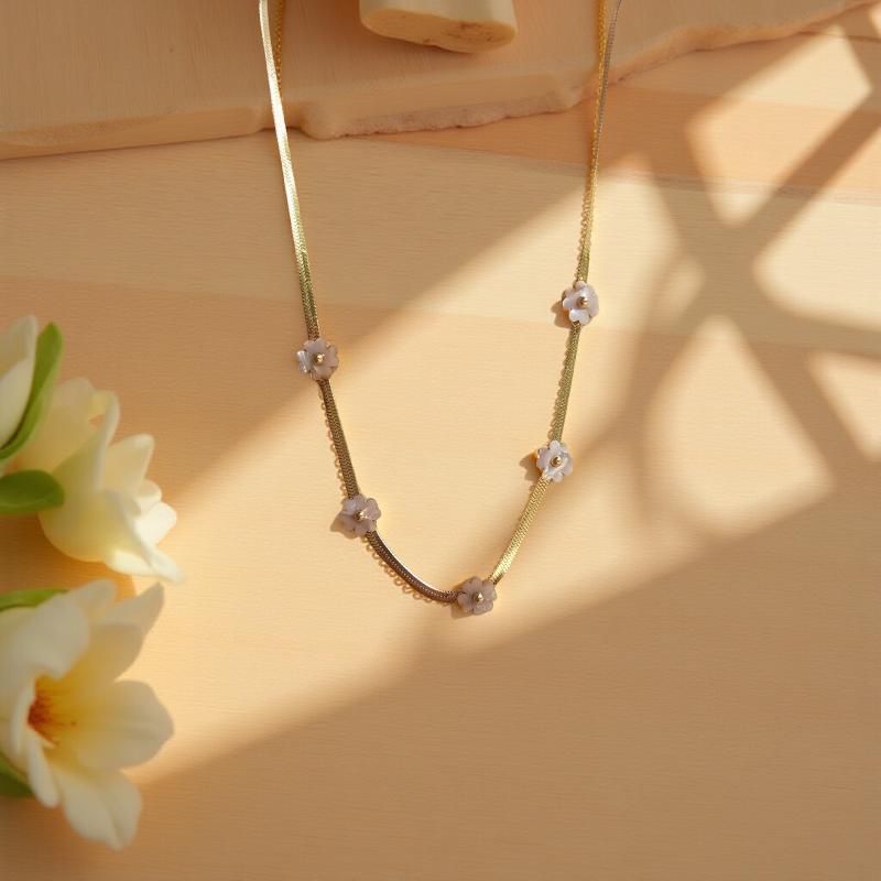 Нежно колие с 5 цветя от бял седеф, поставени на сребриста верижка изработена от висококачествена стомана.