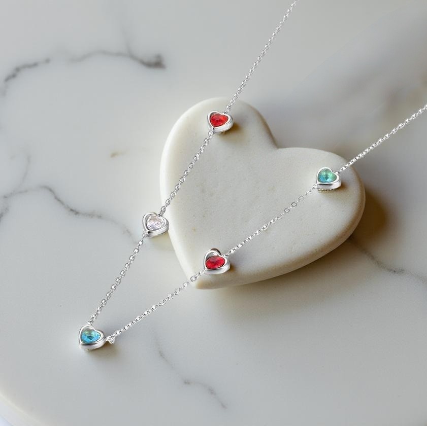Нежно колие с 5  сърца с кристали в различни цветове- червен, бял и син.Изработено от медицинска стомана.