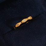 Нежен златист пръстен с вълнообразна халка и гравирани звезди с циркони в центъра